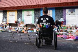 A person looks at a memorial to victims of a mass shooting at a gay club in Colorado, US