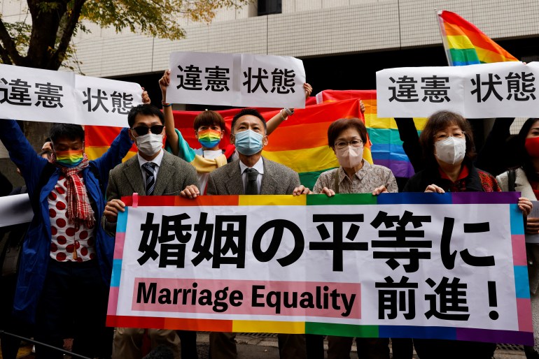 Plaintiffs hold placards that read read "A step towards Marriage Equality". 