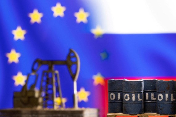 Models of oil barrels and a pump jack are seen in front of displayed EU and Russia flag colours