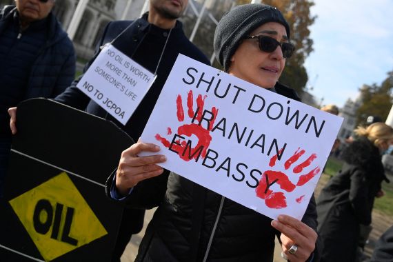Protester holding a banner saying 'Shut Down Iranian Embassy'