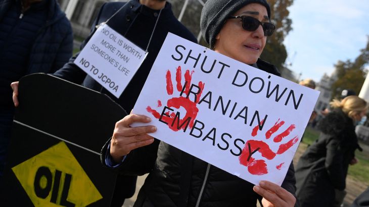 Protester holding a banner saying 'Shut Down Iranian Embassy'
