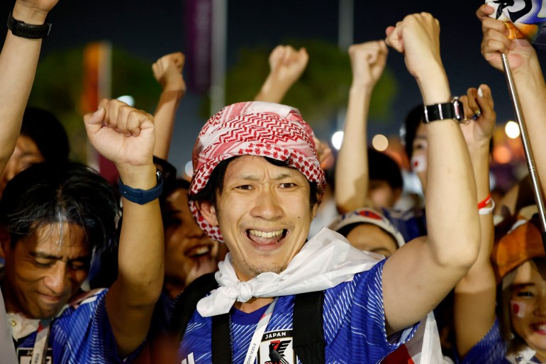 Japan fans celebrate outside the stadium after their match against Spain.