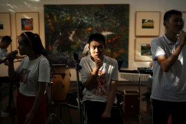 Zu Wenbao, gestures as if he is holding a microphone during a band practice session, at Xing Guang Yi Cai (&#34;Radiant Starlight&#34;), a charity which provides art and music lessons for people with autism spectrum disorder, in Beijing. [Tingshu Wang/Reuters]