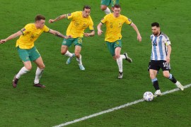 Lionel Messi with the ball against three Aussie defenders.