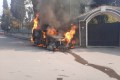 A police vehicle burns as people take part in a protest in Sweida, Syria.