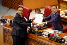 Bambang Wuryanto, head of the parliamentary commission overseeing the amendments to the criminal code, passes the newly passed law to the deputy speaker of parliament.