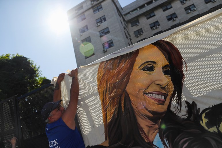 A supporter of Argentina VP Cristina Fernandez de Kirchner hangs a flag depicting her