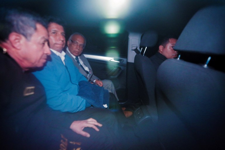 Pedro Castillo sits in the back of a car next to former prime minister Anibal Torres after leaving a police station in Lima