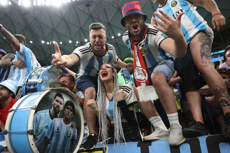 Soccer Football - FIFA World Cup Qatar 2022 - Quarter Final - Netherlands v Argentina - Lusail Stadium, Lusail, Qatar - December 10, 2022 Argentina fans with a drum of former Argentina player Diego Maradona and Argentina's Lionel Messi celebrate qualifying for the Semi Finals REUTERS/Carl Recine