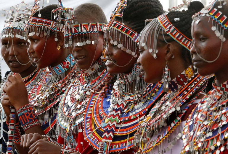 Maasai Olimpiyatları olarak adlandırılan sosyal spor etkinliği sırasında geleneksel boncuklar giymiş Masai kadınları geçit töreni yapıyor.