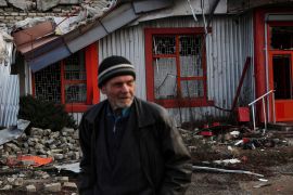 A man walks down by a damaged building in the town of Lyman, Ukraine.