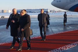 Russian President Vladimir Putin, accompanied by Belarusian President Alexander Lukashenko, walks after disembarking from a plane upon his arrival at the National Airport Minsk in Minsk
