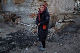 A local resident stands near her residential house destroyed by a Russian military strike, as Russia's attack on Ukraine continues, in Lyman, Ukraine December 19, 2022. REUTERS/Oleksandr Ratushniak