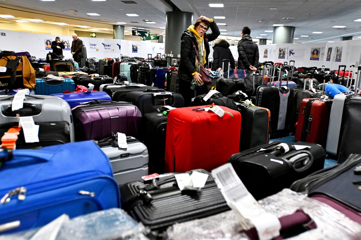 Passengers search for luggage following flight cancellations