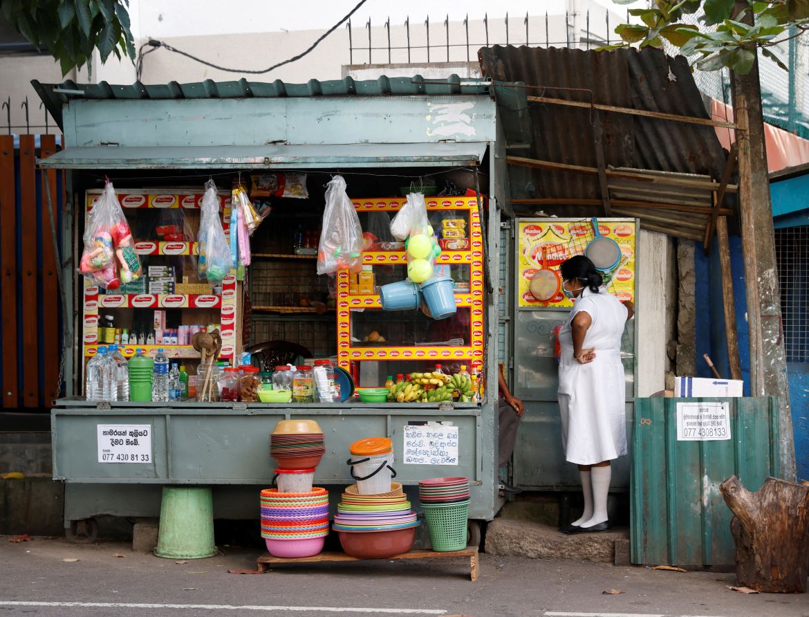 A medical worker talks to a vendor selling household goods and food for patients and their family members, outside Apeksha Hospital, Colombo, Sri Lanka.