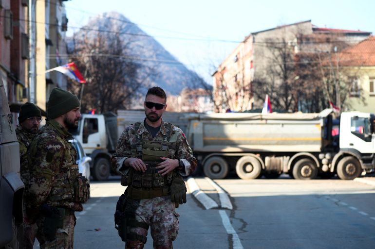 Members of the Italian Armed Forces, part of the NATO peacekeeping mission in Kosovo, stand near a roadblock in the northern part of the ethnically-divided town of Mitrovica