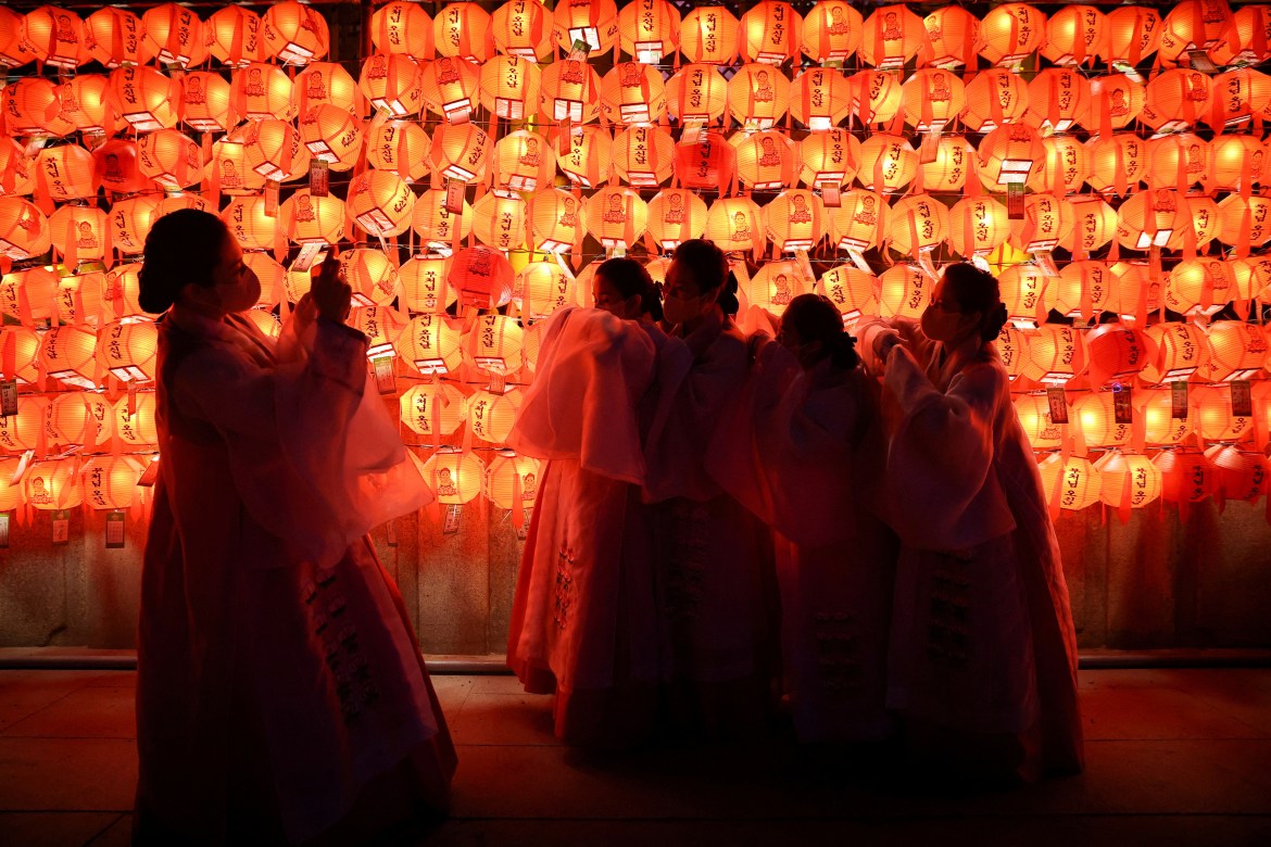 Buddhist faithful take pictures as they celebrate New Year's eve at a temple in Seoul.
