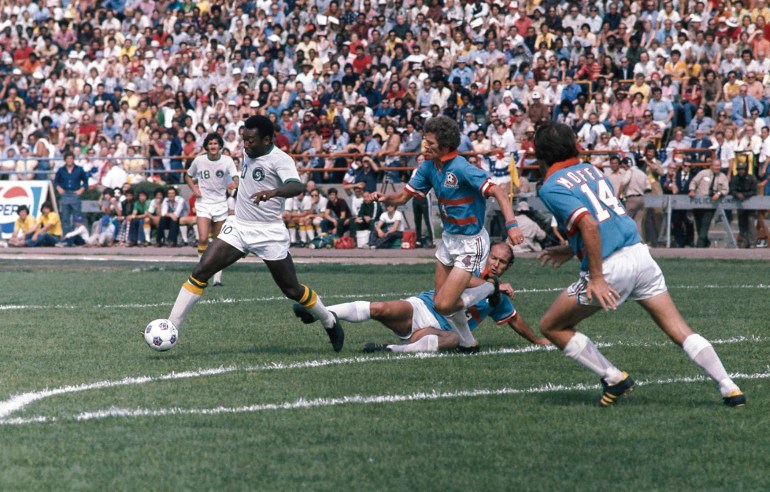 Brazilian footballing legend Pele moving with the ball against three defenders in 1975.