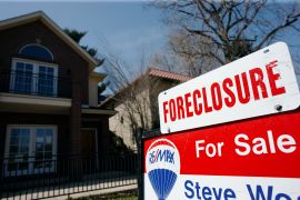 A sign noting the foreclosure status of a single-family home tops the for sale sign in Denver