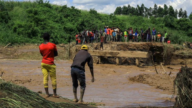Residents gather near a washed-out bridge after flooding on the the River Hululu