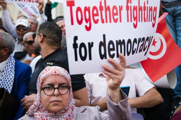 A woman holds up a banner during a protest against Tunisian President Kais Saied in Tunis