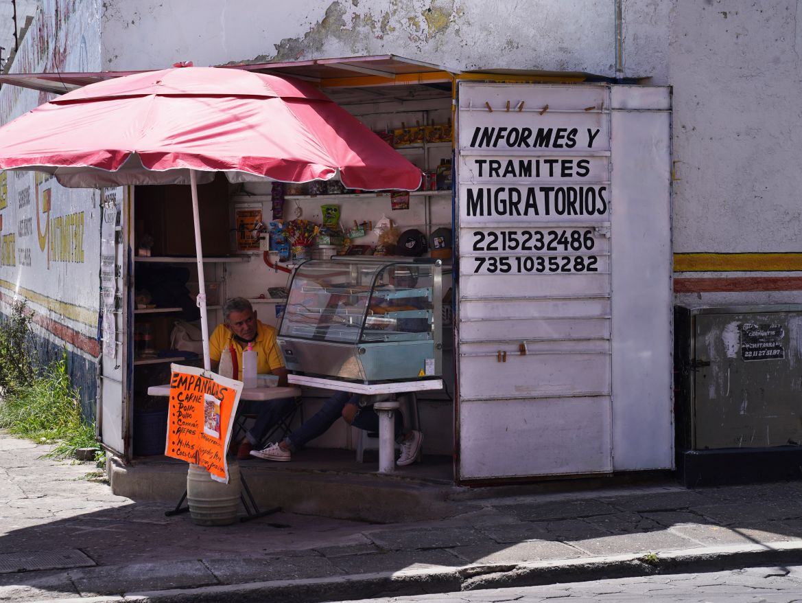 An empanada vendor's stall advertises information, and immigration