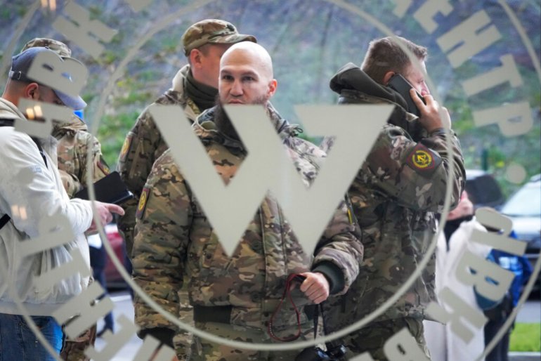 Des visiteurs portant un camouflage militaire se tiennent à l'entrée du Centre Wagner à Saint-Pétersbourg, en Russie, en novembre 2022