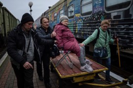 A 94-year-old woman is transported to an evacuation train in Kherson, Ukraine [Evgeniy Maloletka/AP]