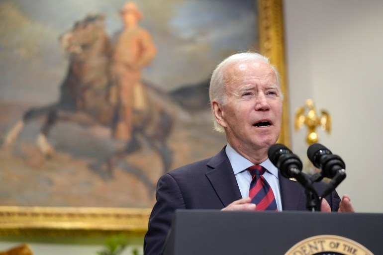 Biden delivers a speech at a White House podium, in front of a painting of a man on horseback