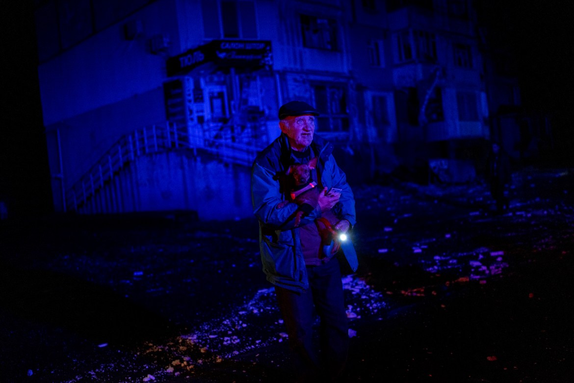 An elderly man holds a dog as he walks amid debris after a Russian attack in Kherson, southern Ukraine, Thursday, Nov. 24, 2022. (AP Photo/Bernat Armangue)