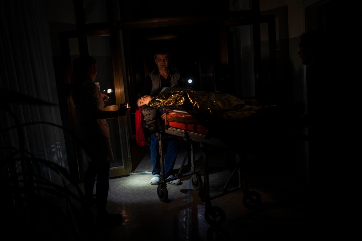 Staff move Arthur Voblikov, 13, to the operating room inside a hospital in Kherson, southern Ukraine, Tuesday, Nov. 22, 2022. Voblikov was injured after a Russian strike, and doctors had to amputate his left arm. (AP Photo/Bernat Armangue)