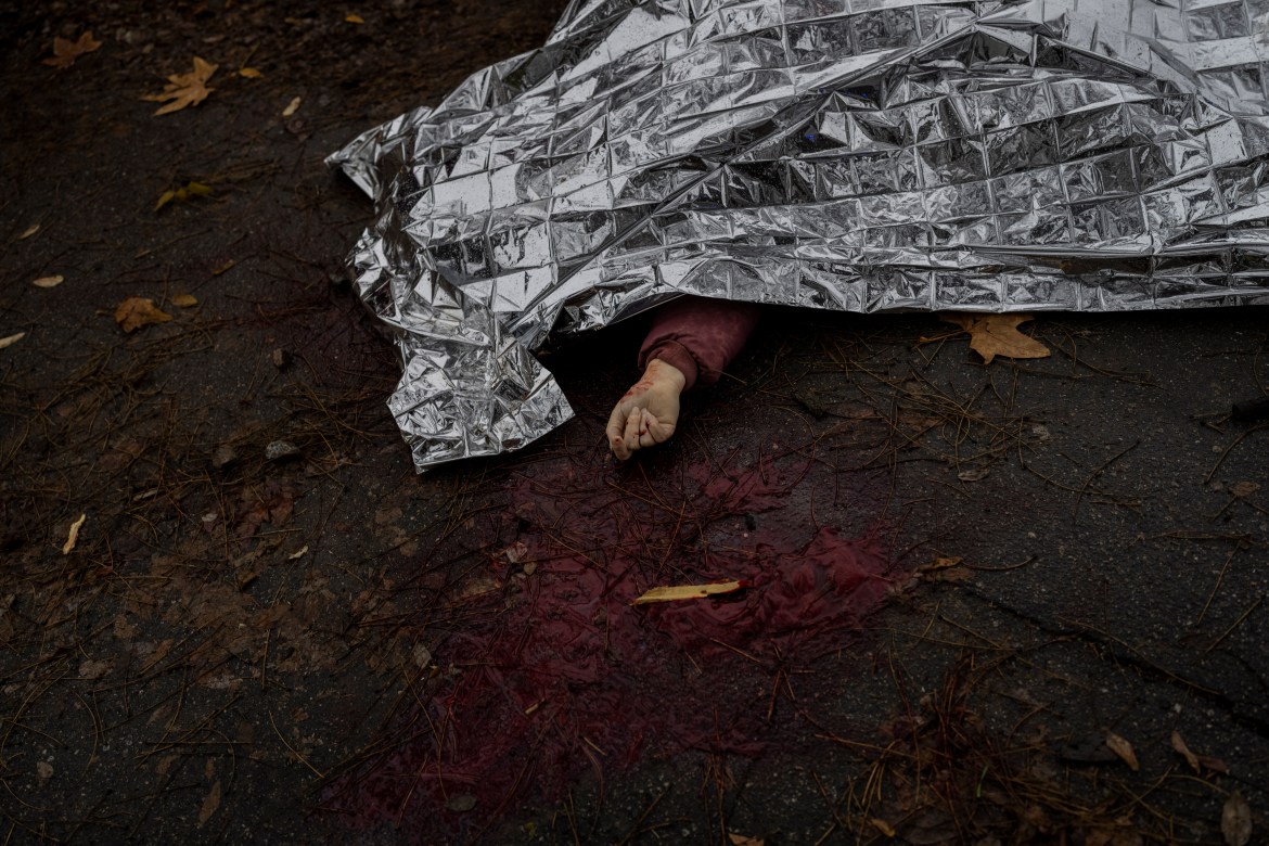 The body of a woman killed during a Russian attack is covered with an emergency blanket before being transported to the morgue in Kherson, southern Ukraine, Friday, Nov. 25, 2022. (AP Photo/Bernat Armangue)