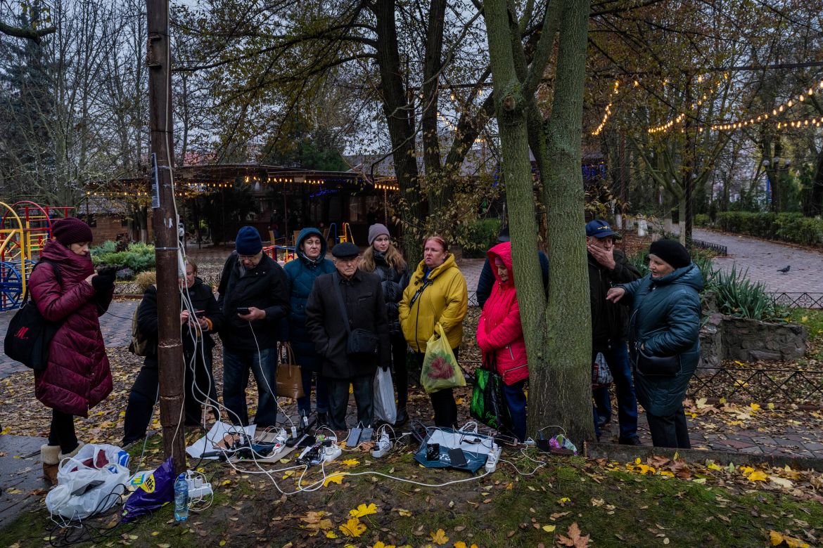 Residents plug in mobile phones and power banks at a charging point in downtown Kherson, southern Ukraine, Sunday, Nov. 20, 2022. (AP Photo/Bernat Armangue)