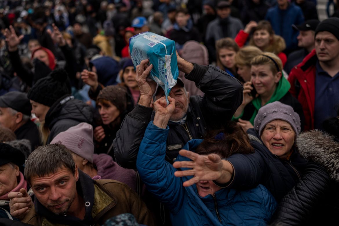 Residents gathering at an aid distribution point receive supplies in downtown Kherson, southern Ukraine, Friday, Nov. 18, 2022. (AP Photo/Bernat Armangue)