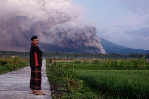 A man looks on as Mount Semeru releases clouds of ash during an eruption on Sunday