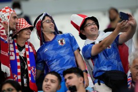 Fans of Japan and Croatia take a selfie as they wait for the start of the World Cup at the Al Janoub Stadium [Eugene Hoshiko/AP Photo]