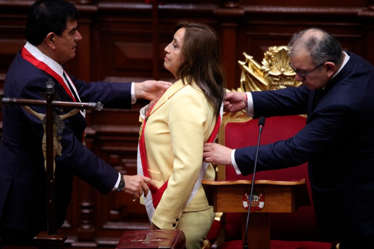 Former Vice President Dina Boluarte receives the presidential sash as she is sworn-in as the new president at Congress in Lima, Peru, Wednesday, Dec. 7, 2022. Peru's Congress voted to remove President Pedro Castillo from office Wednesday and replace him with the vice president, shortly after Castillo tried to dissolve the legislature ahead of a scheduled vote to remove him. At left is Congress President Jose Williams and at right is Jose Cevasco. (AP Photo/Guadalupe Pardo)