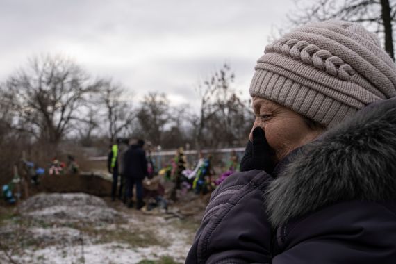 FILE - Tamila Pyhyda cries during the exhumation of her husband Serhii Pyhyda who was killed by Russian forces in the recently retaken town of Vysokopillya, Ukraine, Monday, Dec. 5, 2022. Russian invaders left behind all sorts of trickery as they fled the southern city to jubilation across Ukraine a month ago, and continue to strike it from afar. Life in Kherson is still far from back to normal. (AP Photo/Evgeniy Maloletka, File)