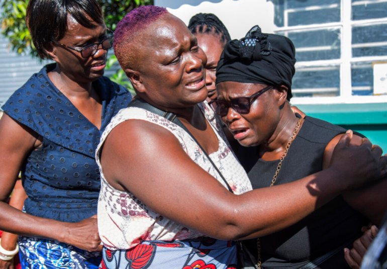 Lemekhani Nyireda'nın annesi Florence Nyirenda, 11 Aralık 2022 Pazar günü Zambiya, Lusaka'daki Kenneth Kaunda Uluslararası Havalimanı'nda aile üyeleri tarafından teselli ediliyor. Rus ordusu için savaşırken hayatını kaybeden 23 yaşındaki Zambiyalı bir öğrencinin cesedi Ukrayna'daki savaşta eve döndü.  Orduya katılmadan önce Rusya'da nükleer mühendislik okuyan Lemekani Nyirenda'nın cenazesi Pazar günü Lusaka'daki Kenneth Kaunda Uluslararası Havalimanı'na ulaştı.  (AP Fotoğrafı/Salim Dawood)