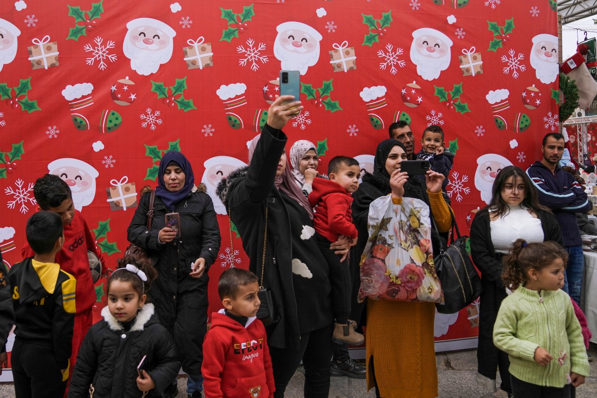 Palestinians visit the decorated Manger Square