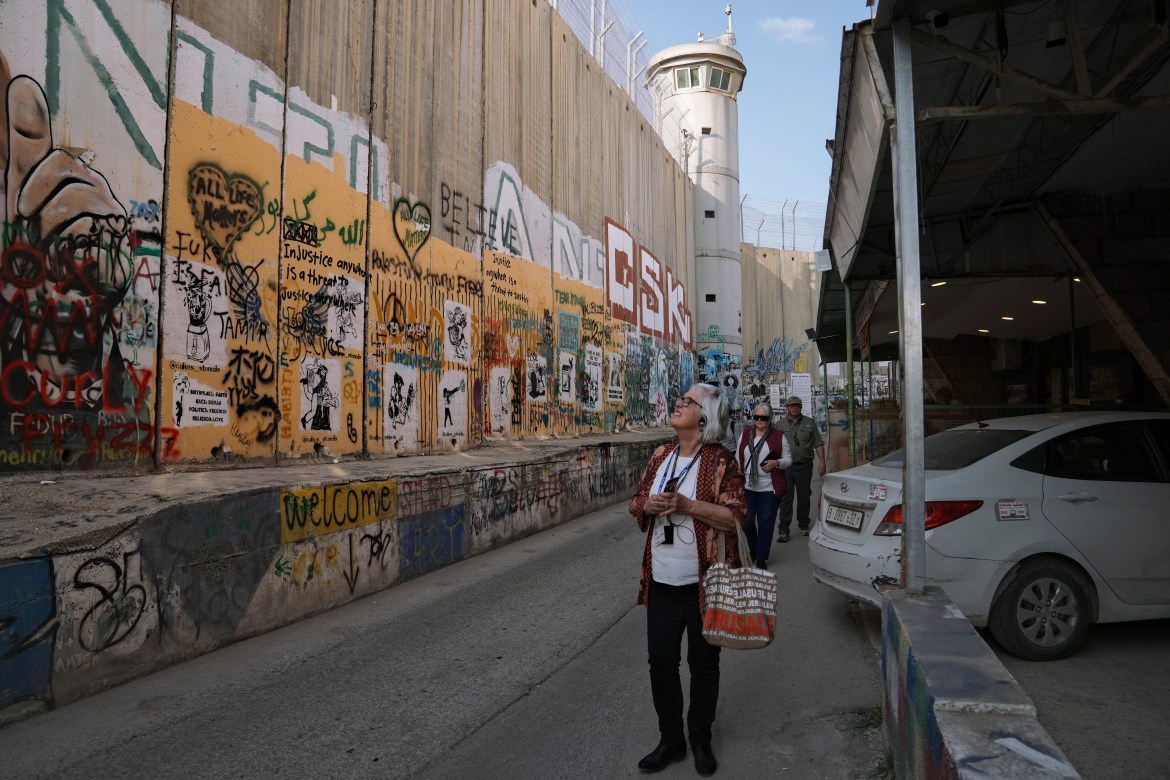 Tourists walk by a section of Israel's separation barrier