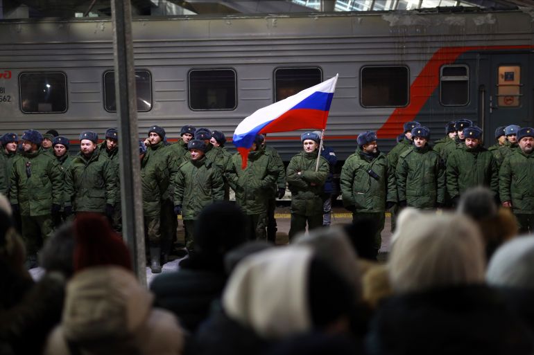 Soldiers who were recently mobilized by Russia for the military operation in Ukraine stand at a ceremony before boarding a train at a railway station in Tyumen, Russia