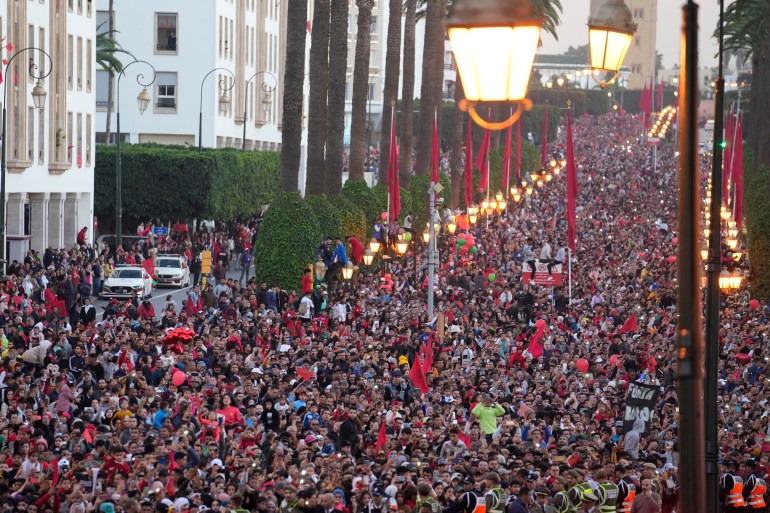 Taraftarlar, Rabat'ın merkezinde Fas milli futbol takımının eve dönüş geçit töreninde kutlama yapıyor