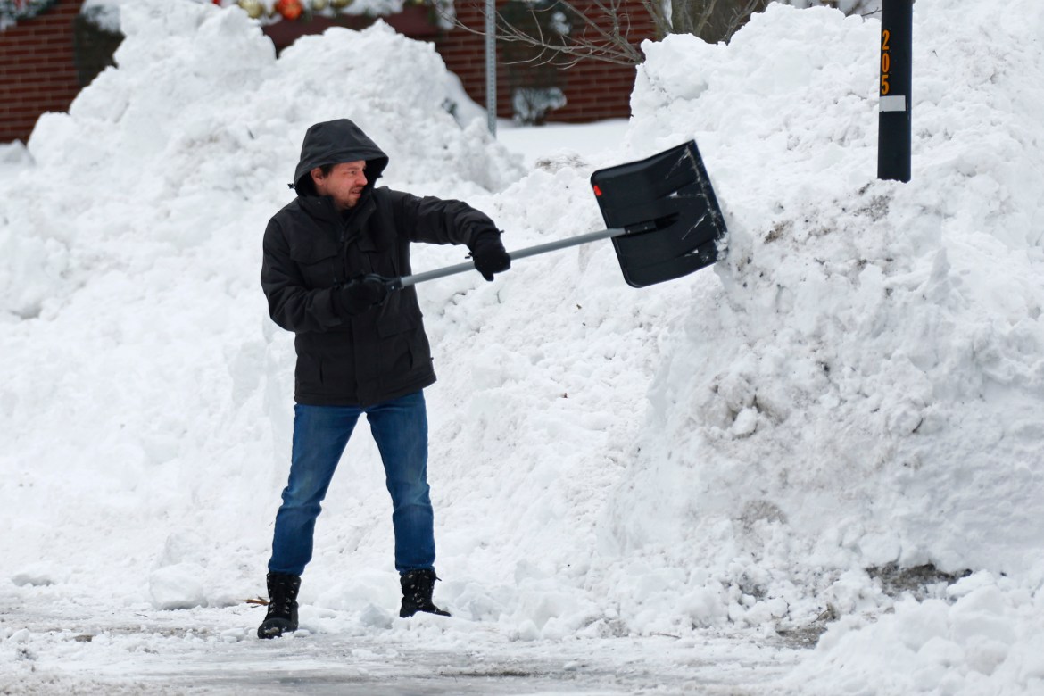 A person clears snow after a winter storm