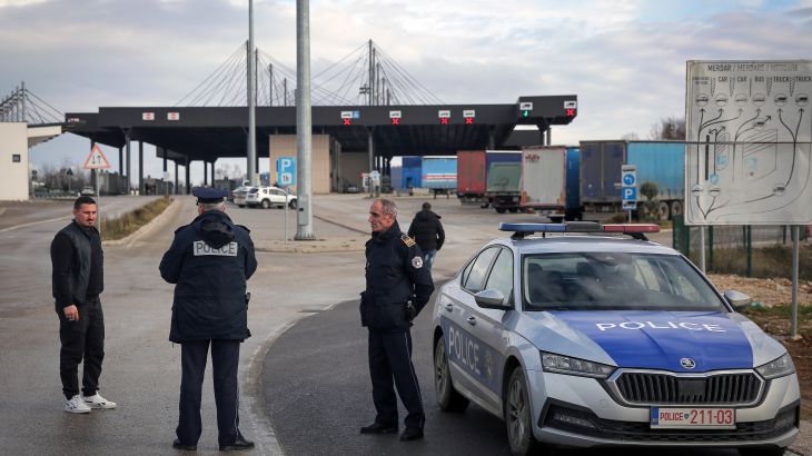 Kosovo police officers inform travelers of the closed Merdare border crossing between Kosovo and Serbia