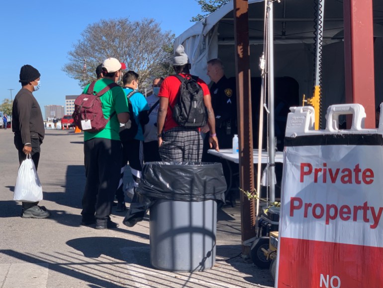Des migrants se tiennent devant le San Antonio Migrant Resource Center à San Antonio, Texas