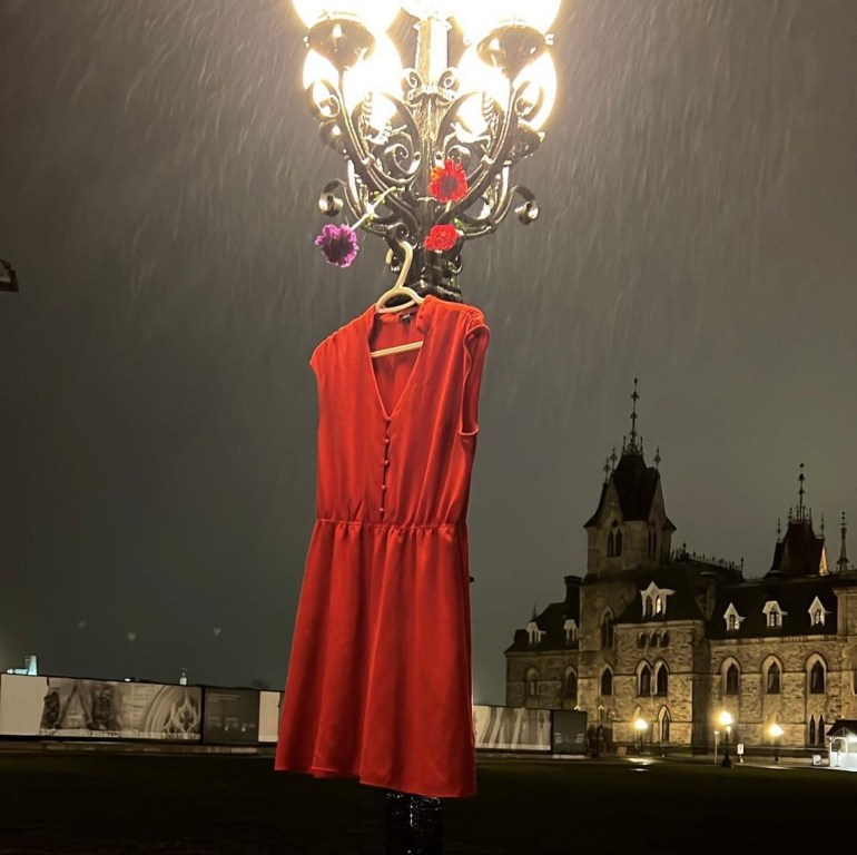 A red dress hangs from a lamp post in Ottawa