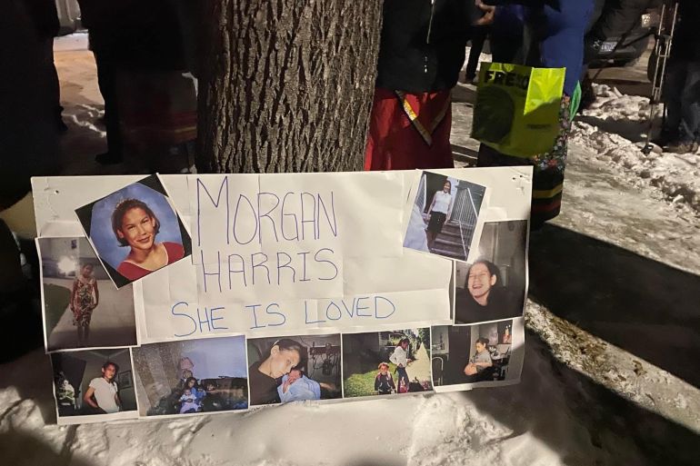 A handmade poster commemorating Morgan Harris leaning against a tree in the snow