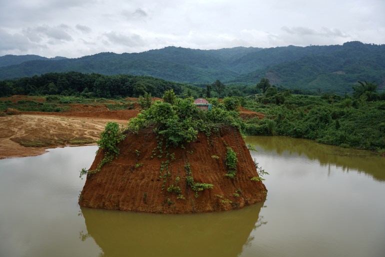 The cemetery of Nam San Yang village has been left isolated in the middle of a lake as earth has been carved away for gold mining