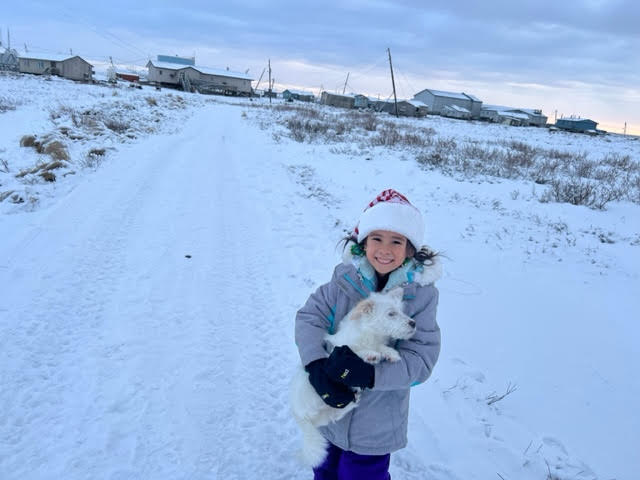 Fille Willow tenant un chien à Newtok enneigé, Alaska